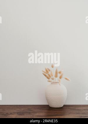 Vase en céramique blanc avec fleurs séchées sur une table en bois brun. Vue de face élégante et minimaliste. Copier l'espace Banque D'Images