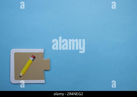 Casse-têtes d'images placés sur le bord d'un fond bleu. Crayon Banque D'Images