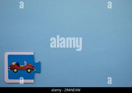 Casse-têtes d'images placés sur le bord de l'arrière-plan bleu. Voiture rouge Banque D'Images