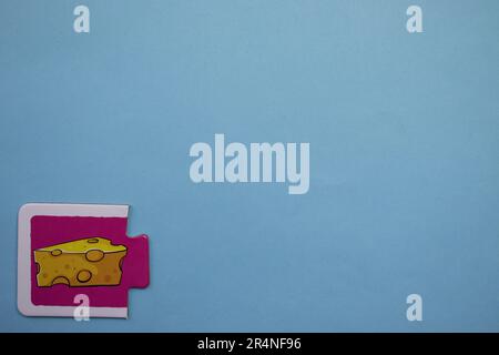 Casse-têtes d'images placés sur le bord d'un fond bleu. Fromage Banque D'Images