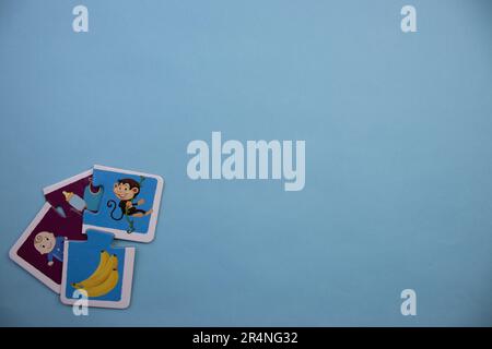 Casse-têtes d'images placés sur le bord de l'arrière-plan bleu. Singe, banane, bébé, choses. Mixte. Banque D'Images