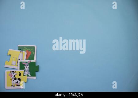 Des puzzles d'information, photographiés d'en haut, placés sur le bord de l'arrière-plan bleu. Vache et lapin. Banque D'Images
