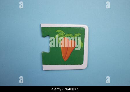 Des puzzles d'information, photographiés d'en haut, placés sur un fond bleu. Carottes d'orange. Banque D'Images