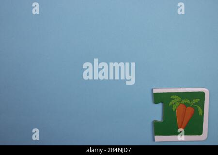 Des puzzles d'information, photographiés d'en haut, placés sur le bord de l'arrière-plan bleu. Carottes d'orange. Banque D'Images
