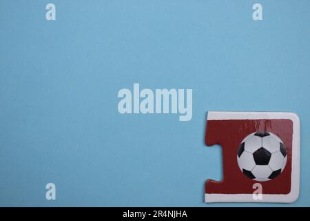 Des puzzles d'information, photographiés d'en haut, placés sur le bord de l'arrière-plan bleu. Ballon de football Banque D'Images