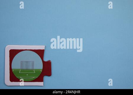 Des puzzles d'information, photographiés d'en haut, placés sur le bord de l'arrière-plan bleu. Une forteresse de football. Banque D'Images