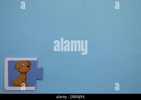Des puzzles d'information, photographiés d'en haut, placés sur le bord de l'arrière-plan bleu. Un chien de compagnie. Banque D'Images
