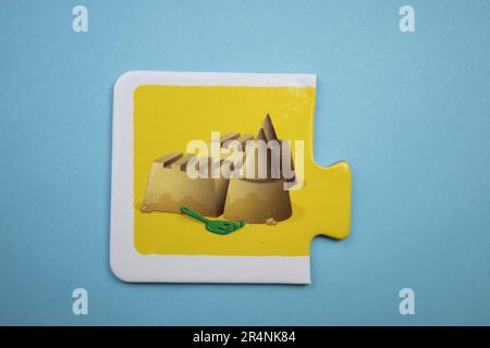 Casse-têtes d'information placés sur un fond bleu. Un château de sable. Banque D'Images