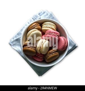 Macarons colorés dans un bol en céramique isolé sur fond blanc Banque D'Images