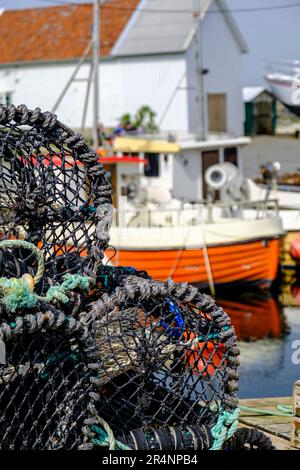 Olberg ; Olbergstranden ; Raege ; Norvège ; 20 mai 2023, Pile de homard ou de crabe pots de pêche avec bateau de pêche à l'arrière-plan et pas de personnes Banque D'Images