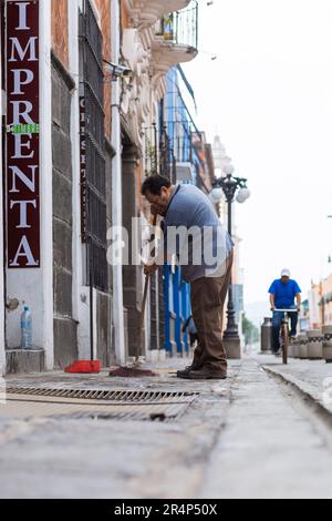 Les citoyens balayent les rues en raison de la chute de cendres volcaniques de Popocatepétl, qui s'est produite sur 21 mai pendant l'éruption de Popocatepétl Banque D'Images
