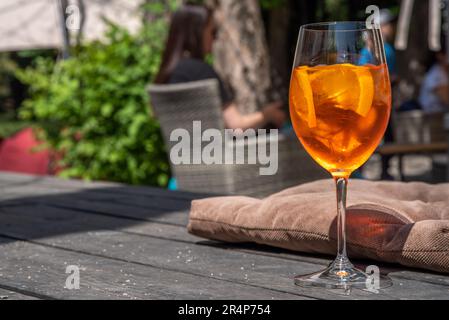 Une fille boit de l'alcool glacé cocktail Aperol spritz sur la terrasse d'été, dans un café ou un restaurant Banque D'Images