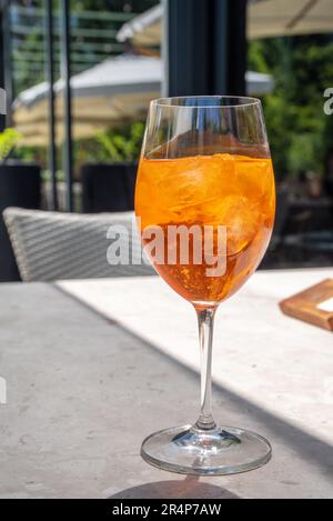 Une fille boit de l'alcool glacé cocktail Aperol spritz sur la terrasse d'été, dans un café ou un restaurant Banque D'Images