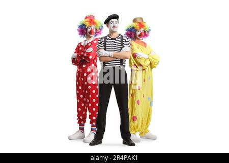 Portrait complet de deux clowns et d'une mime posant avec des bras croisés isolés sur fond blanc Banque D'Images