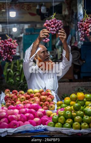 Un marchand ajuste ses raisins dans un marché de la vieille ville de Dhaka, au Bangladesh Banque D'Images