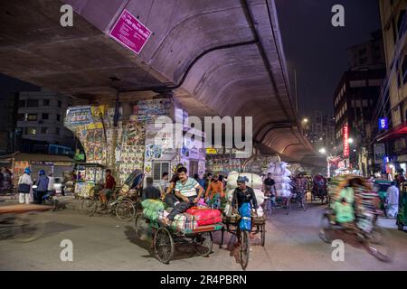 Faites du vélo dans le trafic des pousse-pousse sous un survol de la vieille ville de Dhaka, au Bangladesh Banque D'Images