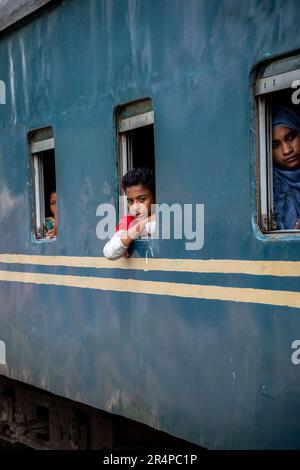 Les passagers regardent par les fenêtres d'un train local à Dhaka, au Bangladesh Banque D'Images