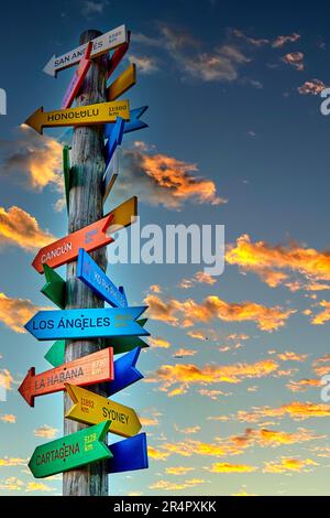 Tronc touristique unique avec des panneaux colorés avec des distances aux différentes destinations touristiques avec un ciel céleste avec des nuages orange dans le backgro Banque D'Images