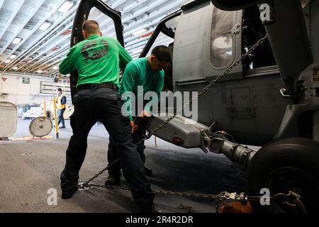 Les marins DE L'OCÉAN ATLANTIQUE (18 mai 2023), affectés à l'escadron de combat de la mer des hélicoptères 26, font l'entretien de préforme sur un HMH-60s Seahawk, dans la baie hangar du navire d'assaut amphibie de classe Wasp USS Bataan (LHD 5). Le Groupe de préparation amphibie de Bataan et l'unité expéditionnaire maritime 26th participent actuellement à l'exercice de l'unité de formation composite du Groupe de grève des transporteurs (COMPTUEX). COMPTUEX est le dernier exercice de pré-déploiement qui certifie la capacité de l’ARG de Bataan et de l’UMM de 26th à mener des opérations militaires par le biais d’une planification conjointe, et à exécuter des scénarios difficiles et réalistes. (É.-U. Bleu marine P Banque D'Images