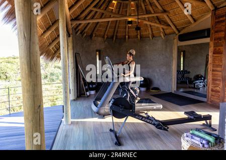 Femme sur le tapis roulant à la salle de gym à Onguma Camp Kala - Onguma Game Reserve, Namibie, Afrique Banque D'Images