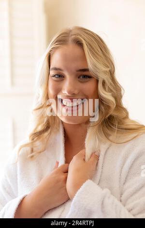 Gros plan portrait de sourire plus grande taille belle jeune femme caucasienne vêtue de peignoir blanc Banque D'Images