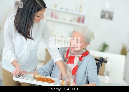 femme servant un repas à une femme blessée Banque D'Images