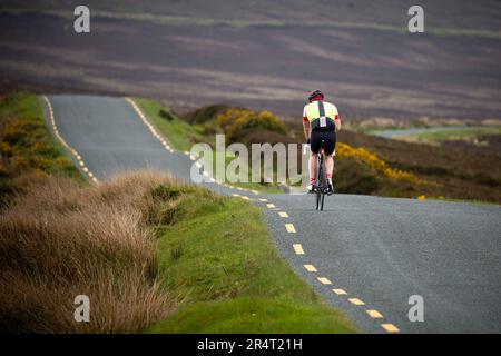 Vue arrière d'un cycliste solitaire dans les montagnes de Wicklow sur la route de Sally Gap Banque D'Images