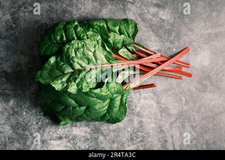 Ensemble de Chard suisse biologique fraîchement récolté sur fond sombre. Banque D'Images