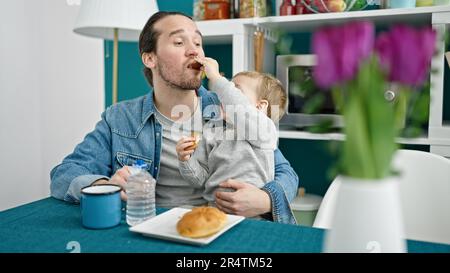 Le père et le fils sont assis sur une table pour prendre le petit déjeuner dans la salle à manger Banque D'Images