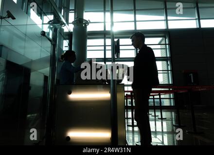 Silhouette d'un passager à la porte avec l'employé vérifiant ses billets. Aéroport international de Zvartnots à Erevan, Arménie. Banque D'Images