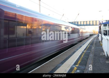 Un train de couleur Bordeaux traverse Hendon Station North London dans un flou alors qu'il roule vers le sud en partant de St Albans. Banque D'Images