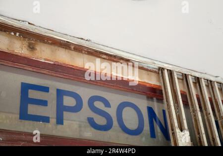 Ho Chi Minh ville, Vietnam - 22 mai 2023 : logo bleu Epson dans une fenêtre d'un centre de service d'imprimante. Vieille publicité sale d'un système électronique japonais m Banque D'Images