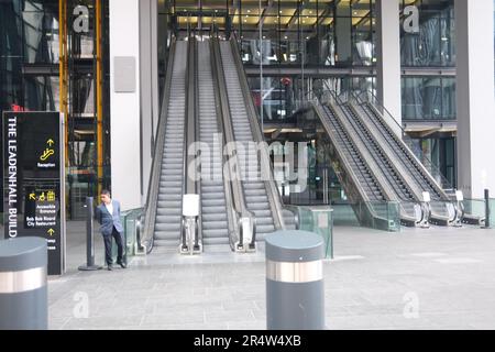 Un individu d'apparence particulière à la base des escaliers mécaniques à l'extérieur du Cheesegrater Building dans la ville de Londres Banque D'Images