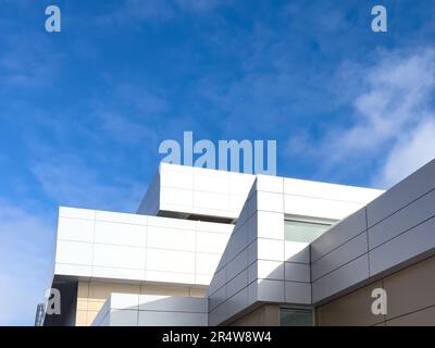 Panneaux composites métalliques externes commerciaux sur un bâtiment avec ciel bleu et nuages en arrière-plan. Les panneaux composites métalliques durables sont deux nuances Banque D'Images