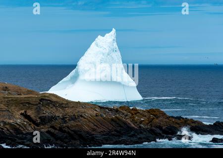 Une grande formation d'iceberg blanc flottant dans l'océan froid avec des couches de glace texturée et de neige. La glace est en transition fondant à partir des rayons chauds. Banque D'Images