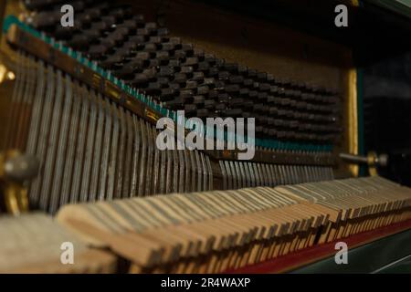 Pièces internes d'un vieux piano gros plan - mécanique, cordes. Mise au point sélective. Détails d'un instrument de musique de l'intérieur Banque D'Images