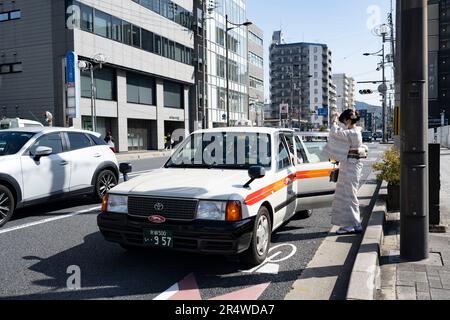 Kyoto, Japon. 7th mars 2023. Les femmes des kimonos japonais traditionnels sont à bord d'un taxi pendant leurs vacances. Kyoto (äº-éƒ½) est une grande ville historique du Japon, riche en patrimoine culturel et en charme traditionnel. Connu pour ses temples emblématiques, ses jardins pittoresques et ses monuments historiques comme Kinkaku-ji et Fushimi Inari Taisha, Kyoto offre un aperçu du passé du Japon. Ses festivals animés, sa cuisine exquise et son atmosphère sereine captivent les visiteurs du monde entier. C'est un centre animé pour l'industrie du tourisme japonais et accueille de nombreuses entreprises comme Nintendo. Le Japon a une population en déclin et Banque D'Images