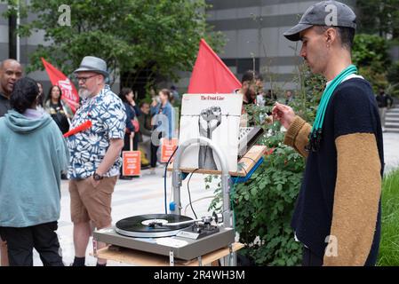 Londres, Royaume-Uni. 30 mai 2023. Un DJ joue de la musique reggae pour frapper des travailleurs de l'association caritative sans-abri St Mungo's alors qu'ils protestent à l'extérieur du siège de l'association à Tower Hill dans un conflit sur les salaires. Les travailleurs, membres du syndicat Unite, ont commencé une grève d'un mois sur les bas salaires ayant reçu une offre de salaire inférieure à l'inflation de 2,25%. Crédit : Ron Fassbender/Alamy Live News Banque D'Images