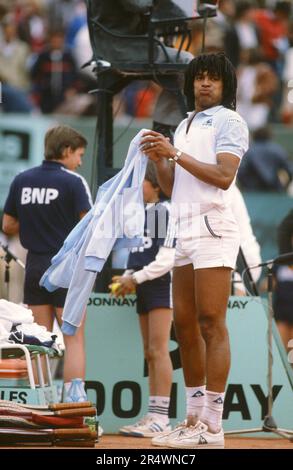 Yannick Noah, joueur de tennis français, pendant la phase de repos d'un match de singles masculin de l'Open de France. Stade Roland Garros, mai 1983. Banque D'Images