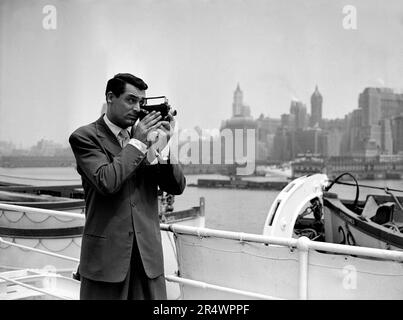 Cary Grant filmant New York à bord du paquebot Ile-de-France sur le chemin du retour de France. Banque D'Images