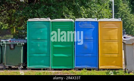 Toilettes portables fermées colorées sur une pelouse utilisée lors d'événements publics Banque D'Images