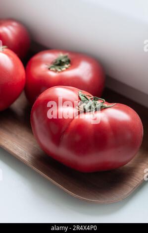 Délicieuses tomates rouges mûres d'été sur plateau en bois Banque D'Images