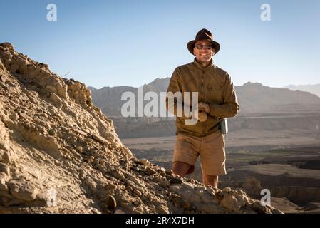 Portrait d'Explorer sur le flanc de la montagne aux ruines du Royaume de Guge et le paysage sombre de la vallée de Sutlej dans les montagnes de l'Himalaya Banque D'Images