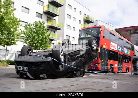 Un bus approche des suites d'un accident de voiture dans lequel un hayon Nissan renversé demeure sur le côté de la route entre Brixton et Camberwell sur Coldport Lane, le 30th mai 2023, à Londres, en Angleterre. Banque D'Images