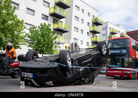 Un bus approche des suites d'un accident de voiture dans lequel un hayon Nissan renversé demeure sur le côté de la route entre Brixton et Camberwell sur Coldport Lane, le 30th mai 2023, à Londres, en Angleterre. Banque D'Images