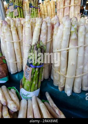 Gros plan de la nourriture encore la vie d'asperges blanches et vertes en vente dans un marché de légumes de Paris, France Banque D'Images