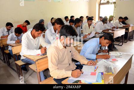 Les élèves intermédiaires résolvent les documents d'examen pendant l'examen annuel dans un centre d'examen sous la supervision du Conseil de l'enseignement intermédiaire et secondaire, à Hyderabad, mardi, 30 mai 2023. Banque D'Images