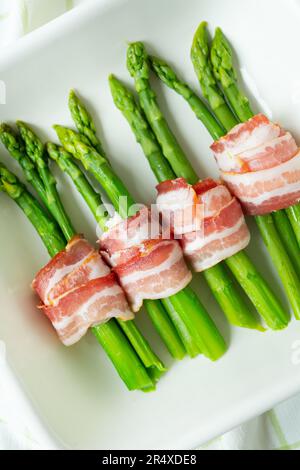 Asperges vertes cuites au bacon et aux épices. Nourriture très savoureuse et saine. Vue de dessus. Photo verticale Banque D'Images