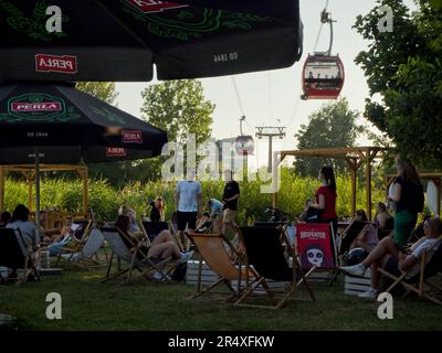 Ville plage près de la rivière Odra avec des téléphériques, des parasols de plage et des personnes se détendant et socialisant sur des chaises longues, Wroclaw, Pologne © Renzo Frontoni / axi Banque D'Images