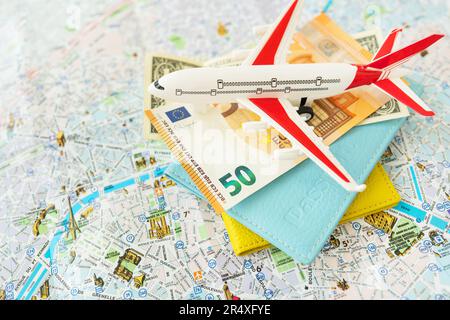 Composition de la carte de la ville de Paris avec billets en euros, dollars, passeports et avion à jouets. Concept de voyage et de vacances Banque D'Images